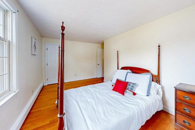 bedroom with wood finished floors, baseboards, and a baseboard radiator