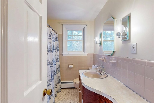 bathroom with vanity, a wainscoted wall, a baseboard heating unit, tile walls, and toilet