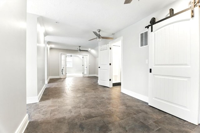 8 Fitch Farm Way, Southampton, MA 01073 - unfurnished living room featuring a barn door, ceiling fan, stone finish floors, and baseboards