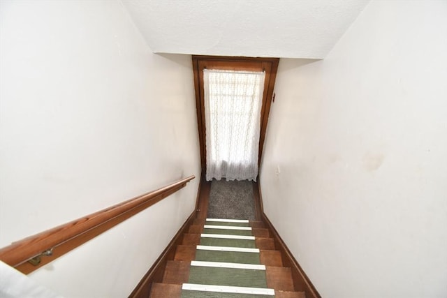 stairs with a textured ceiling