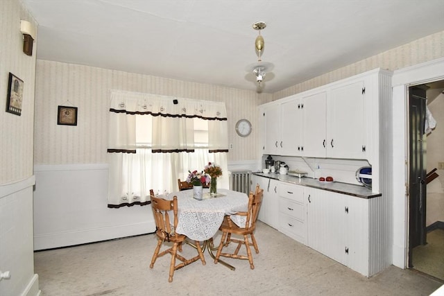 dining area featuring wallpapered walls and a wainscoted wall
