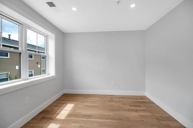 spare room with recessed lighting, light wood-style flooring, baseboards, and fire sprinkler in ceiling