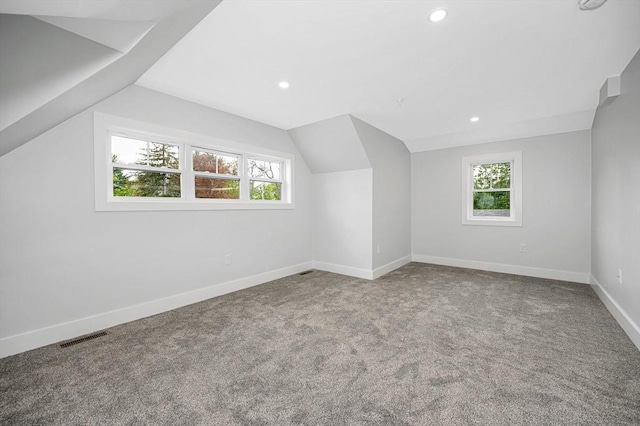 additional living space with healthy amount of natural light, carpet, vaulted ceiling, baseboards, and recessed lighting