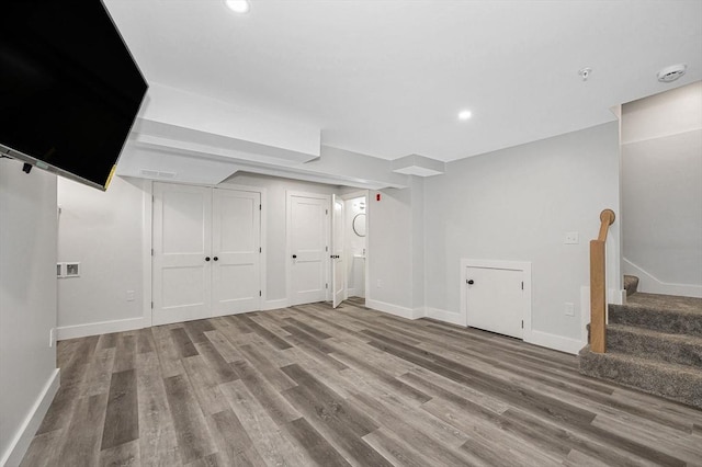 finished basement featuring wood finished floors, stairway, baseboards, and recessed lighting