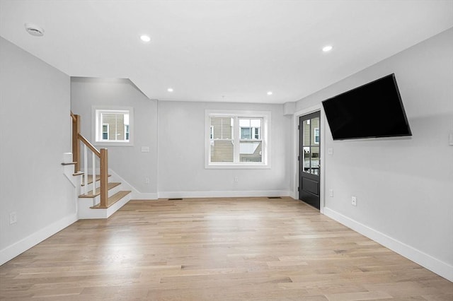 unfurnished living room with stairway, light wood-type flooring, recessed lighting, and baseboards