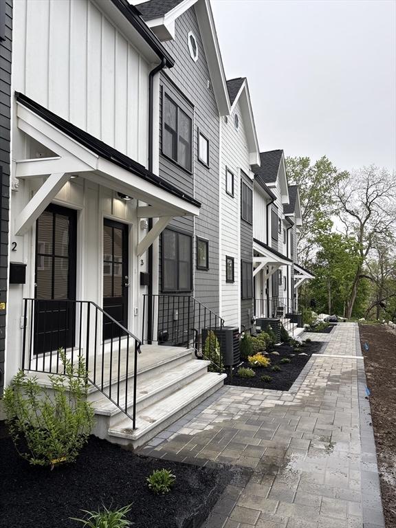 doorway to property featuring board and batten siding and cooling unit