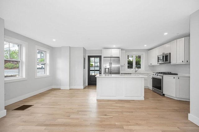kitchen with stainless steel appliances, plenty of natural light, light countertops, and recessed lighting
