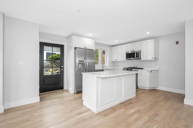 kitchen with stainless steel appliances, healthy amount of natural light, white cabinetry, light countertops, and recessed lighting