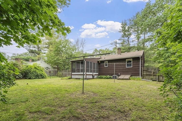 471 Lowell St, Reading, MA 01867 - rear view of house featuring a sunroom, a fenced backyard, and a chimney