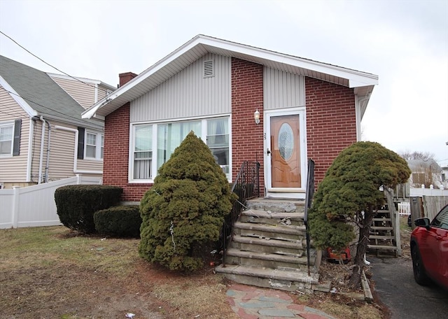 view of front of property featuring brick siding and fence