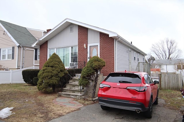 view of front of property featuring brick siding and fence