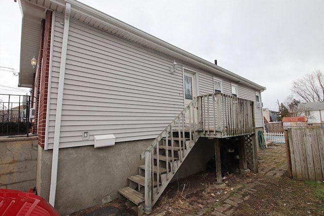 rear view of house featuring stairway and fence