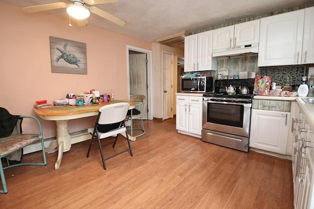 kitchen featuring white cabinets, under cabinet range hood, stainless steel appliances, and light wood finished floors