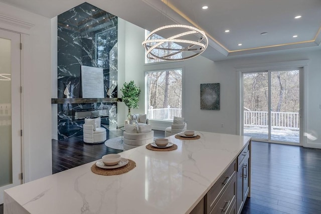 dining room featuring dark wood-type flooring, an inviting chandelier, and a tray ceiling