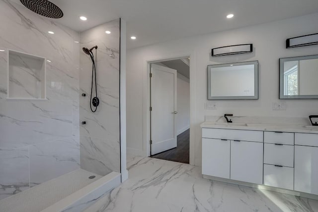 bathroom featuring tiled shower and vanity