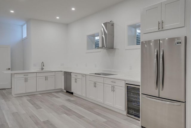 kitchen featuring sink, beverage cooler, white cabinets, and appliances with stainless steel finishes