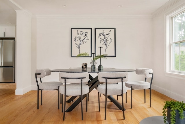 dining room featuring light hardwood / wood-style flooring and crown molding