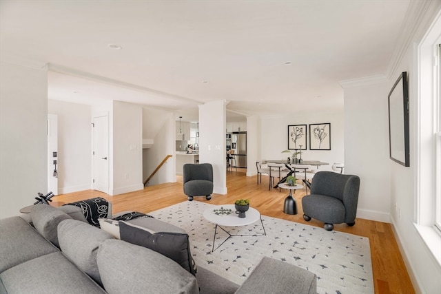 living room with light wood-type flooring and crown molding