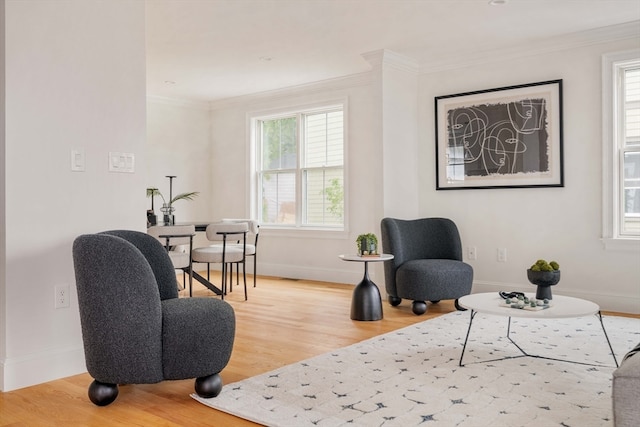 living area featuring a wealth of natural light, wood-type flooring, and crown molding