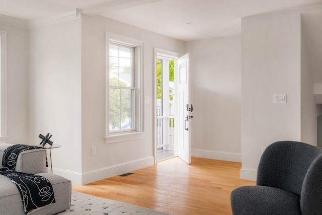 foyer with light wood-type flooring and crown molding