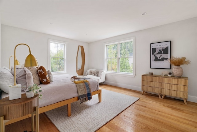 bedroom with light hardwood / wood-style floors and multiple windows