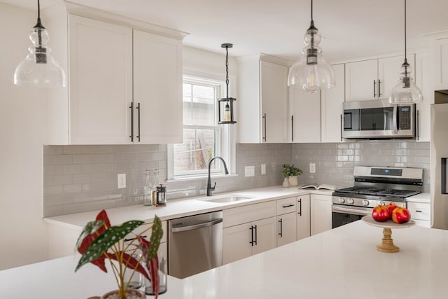 kitchen with stainless steel appliances, backsplash, sink, and white cabinetry