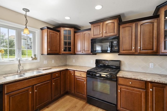 161 Bear Hole Rd, West Springfield, MA 01089 - kitchen with pendant lighting, a sink, light stone counters, black appliances, and light wood-style floors