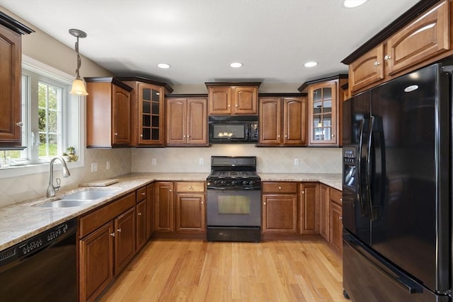 161 Bear Hole Rd, West Springfield, MA 01089 - kitchen with brown cabinets, hanging light fixtures, a sink, light wood finished floors, and black appliances