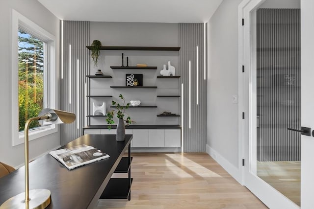 bar with light hardwood / wood-style flooring and white cabinets