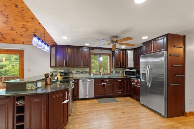 50 New Jersey Rd, Tewksbury, MA 01876 - kitchen with stainless steel appliances, a sink, a peninsula, light wood finished floors, and backsplash
