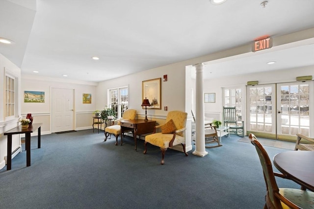 living area featuring decorative columns, french doors, and dark colored carpet