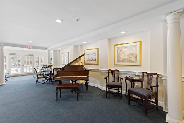 living area with dark carpet and decorative columns