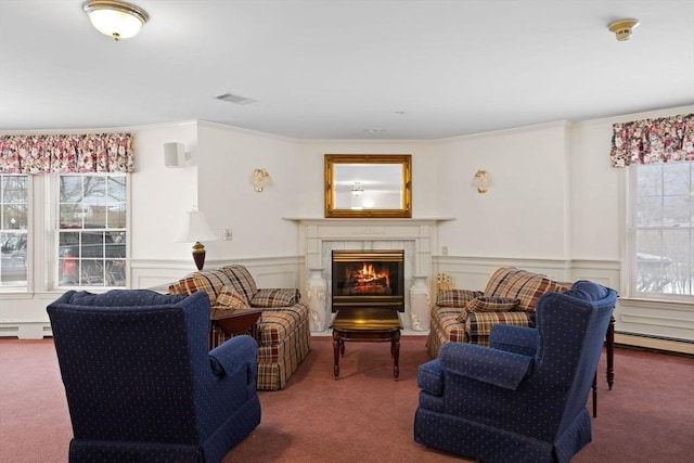 living room with carpet floors, a tiled fireplace, ornamental molding, and a baseboard radiator