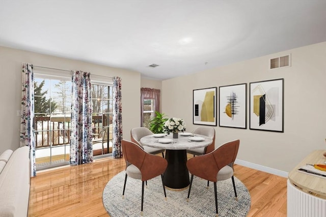 dining space with light hardwood / wood-style floors