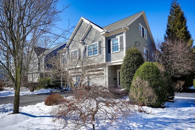 view of snowy exterior with a garage