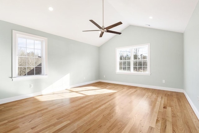 spare room featuring plenty of natural light, ceiling fan, light wood-type flooring, and vaulted ceiling