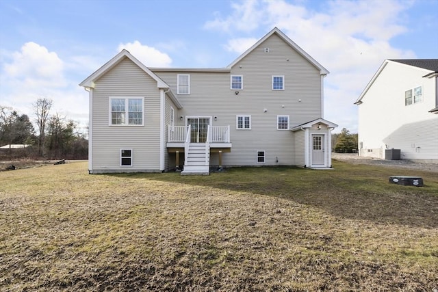 rear view of property featuring a lawn, a wooden deck, and central air condition unit