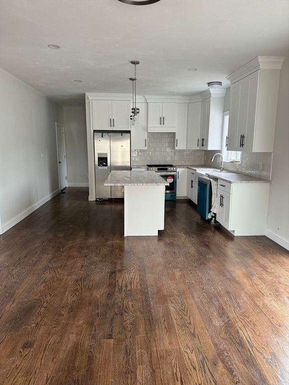 kitchen with dark hardwood / wood-style flooring, stainless steel appliances, a center island, white cabinetry, and hanging light fixtures