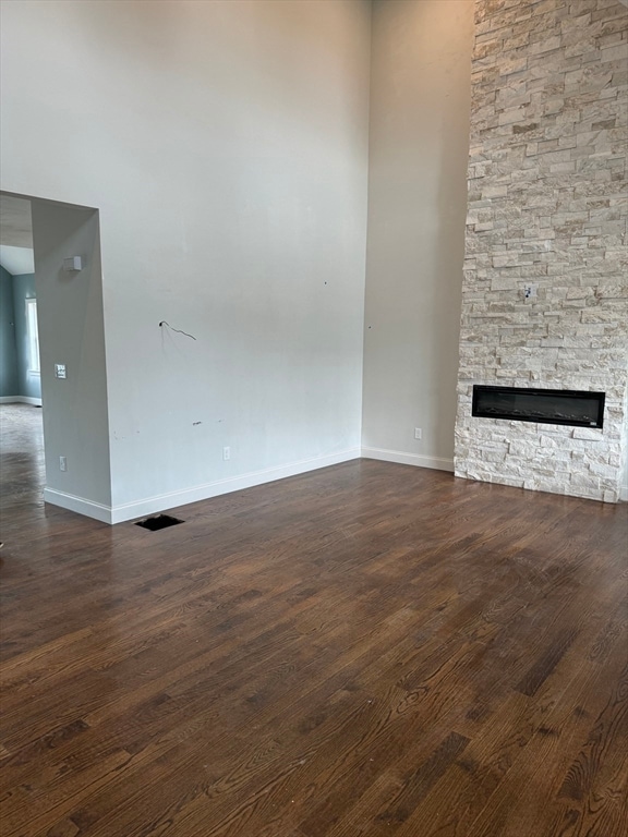 unfurnished living room with dark hardwood / wood-style floors and a fireplace