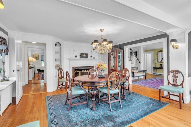 40 Pleasant St, Dover, MA 02030 - dining space featuring crown molding, built in shelves, stairway, and light wood-type flooring