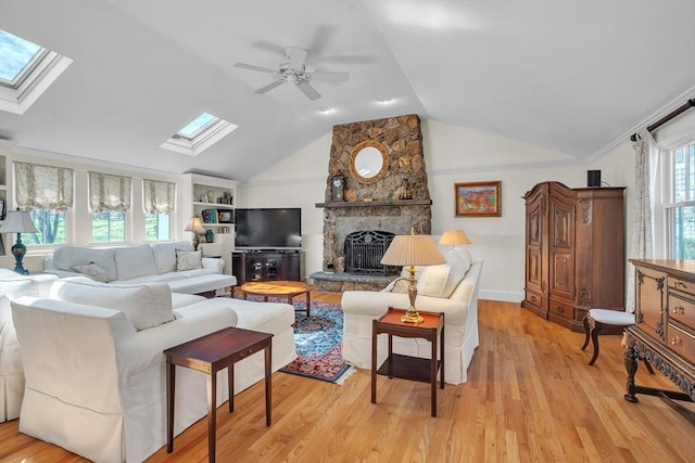 40 Pleasant St, Dover, MA 02030 - living area with a fireplace, light wood-style floors, baseboards, lofted ceiling with skylight, and a ceiling fan