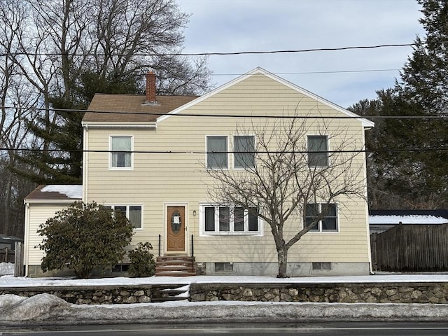 view of front of property featuring entry steps, fence, and a chimney