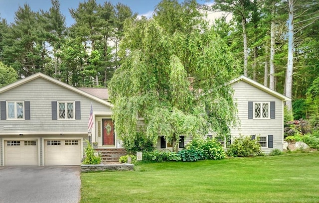 13 Tamarack Rd, Medfield, MA 02052 - split level home with driveway, a front yard, a garage, and view of wooded area