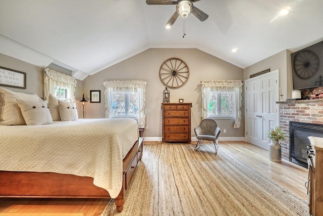 13 Tamarack Rd, Medfield, MA 02052 - bedroom featuring multiple windows, light wood-style floors, vaulted ceiling, a fireplace, and a ceiling fan