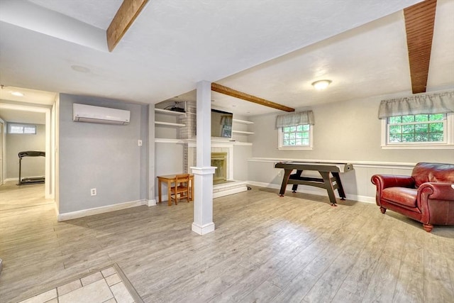 13 Tamarack Rd, Medfield, MA 02052 - below grade area with a wall unit AC, light wood-style flooring, and a fireplace with raised hearth