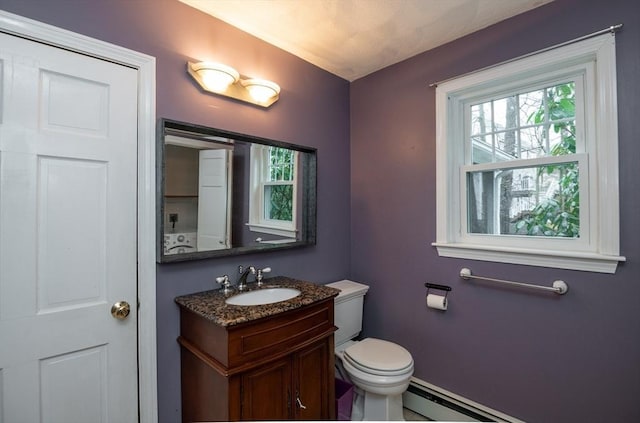 bathroom with toilet, baseboards, baseboard heating, and vanity