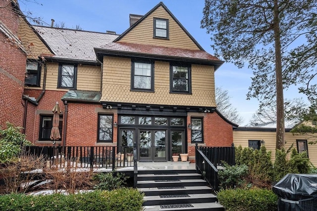 exterior space featuring brick siding, a chimney, and french doors