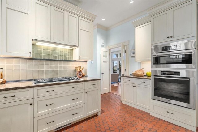 kitchen with ornamental molding, stainless steel appliances, under cabinet range hood, backsplash, and recessed lighting