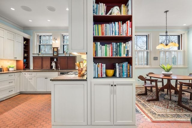 interior space with a chandelier, recessed lighting, and crown molding