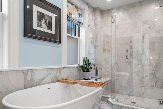 full bathroom featuring a freestanding bath, marble finish floor, and a marble finish shower